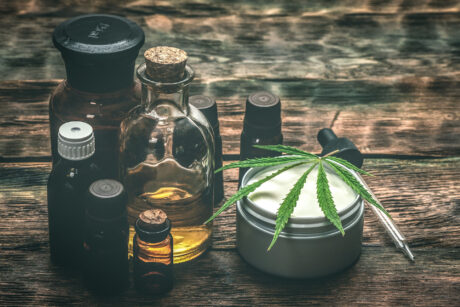 Cannabis face cream or moisturizer jar and cbd oil bottles concept